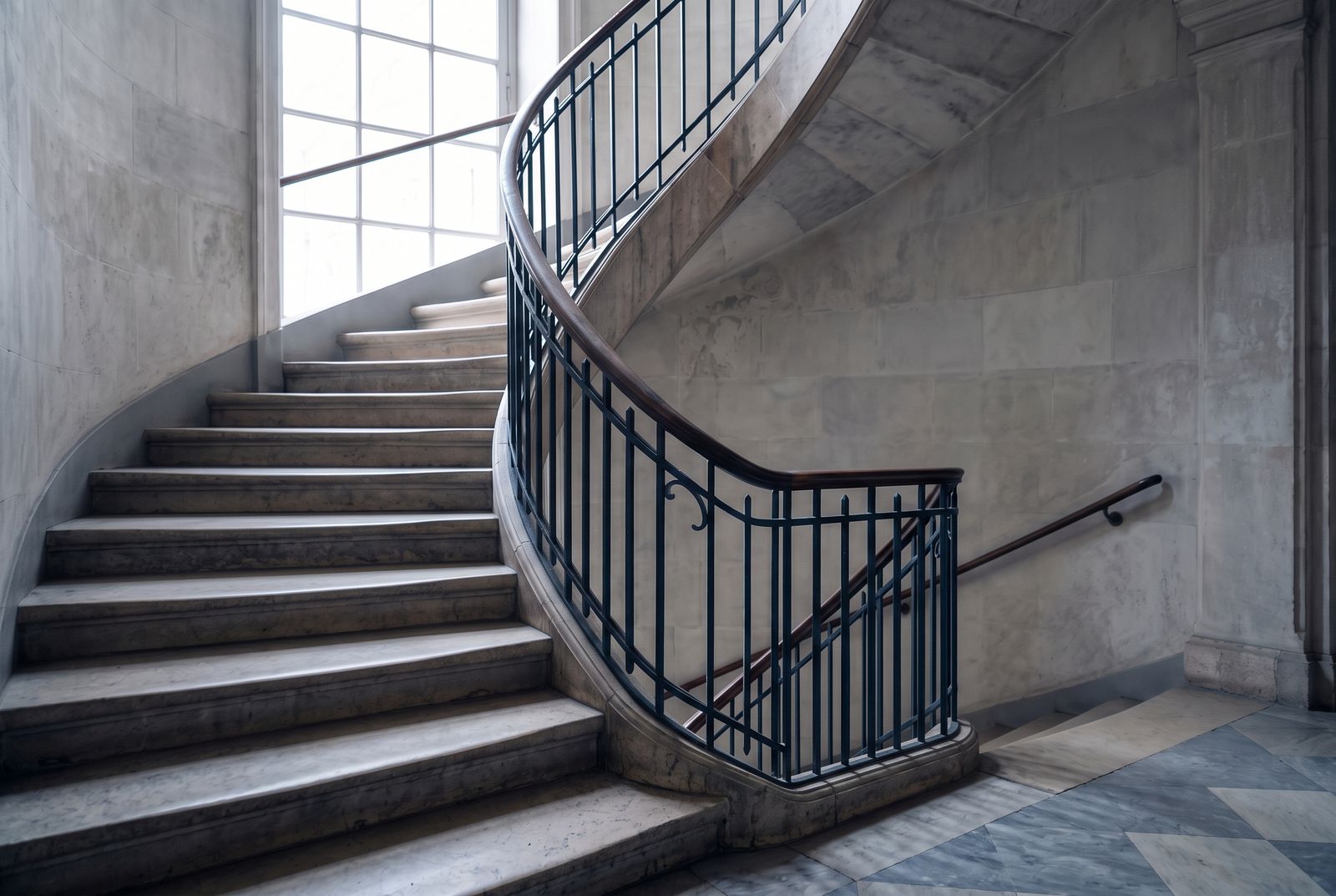 Escalera de piedra en espiral con barandilla de hierro